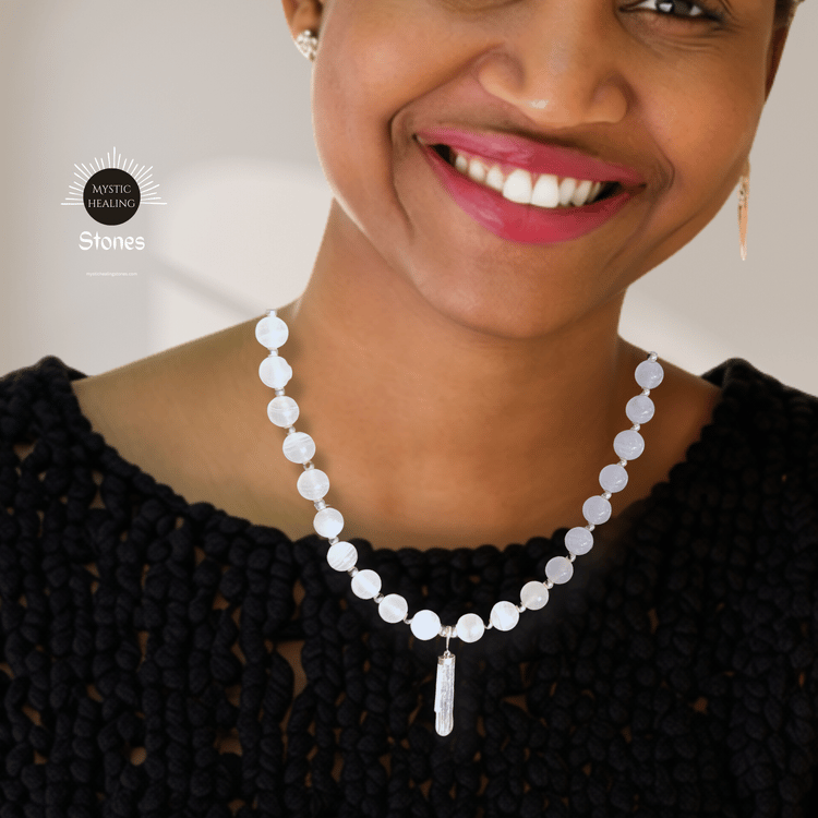 Smiling woman wearing a pink calcite bead necklace with a crystal pendant.