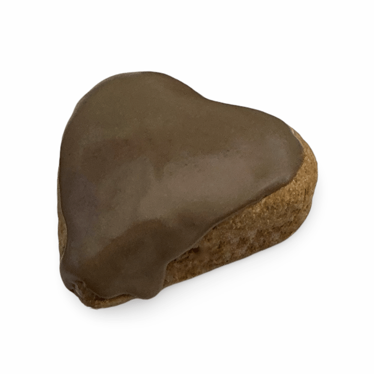 Galleta de jengibre en forma de corazón con glaseado de chocolate sobre un fondo negro.