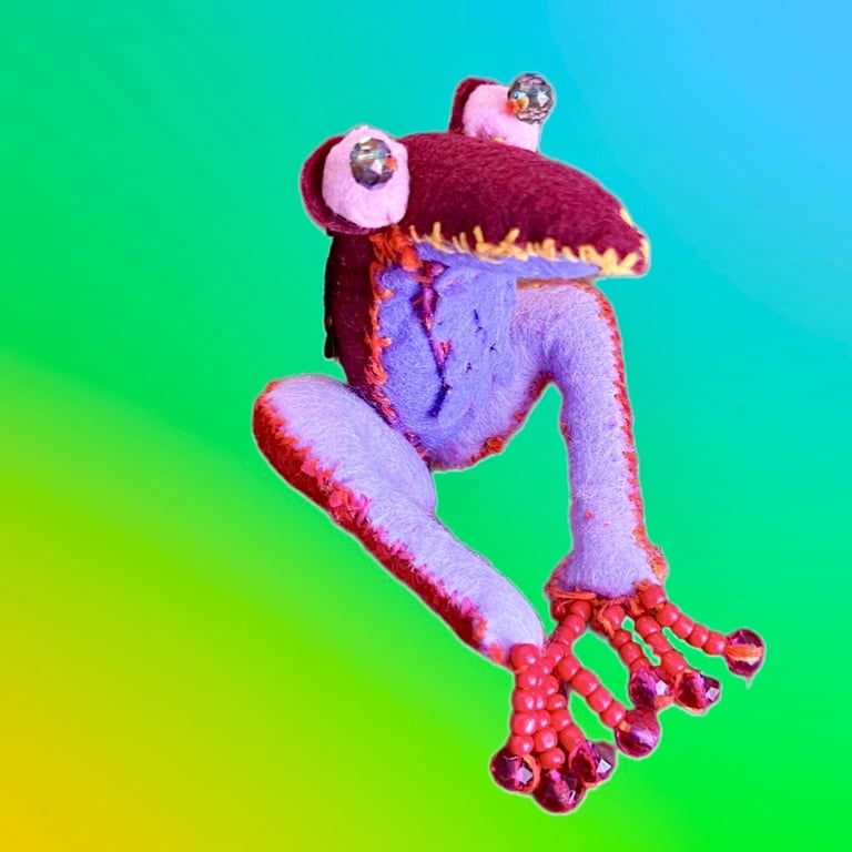 bird-like alien critter. Berry/lavender color way with beaded eyes and toes