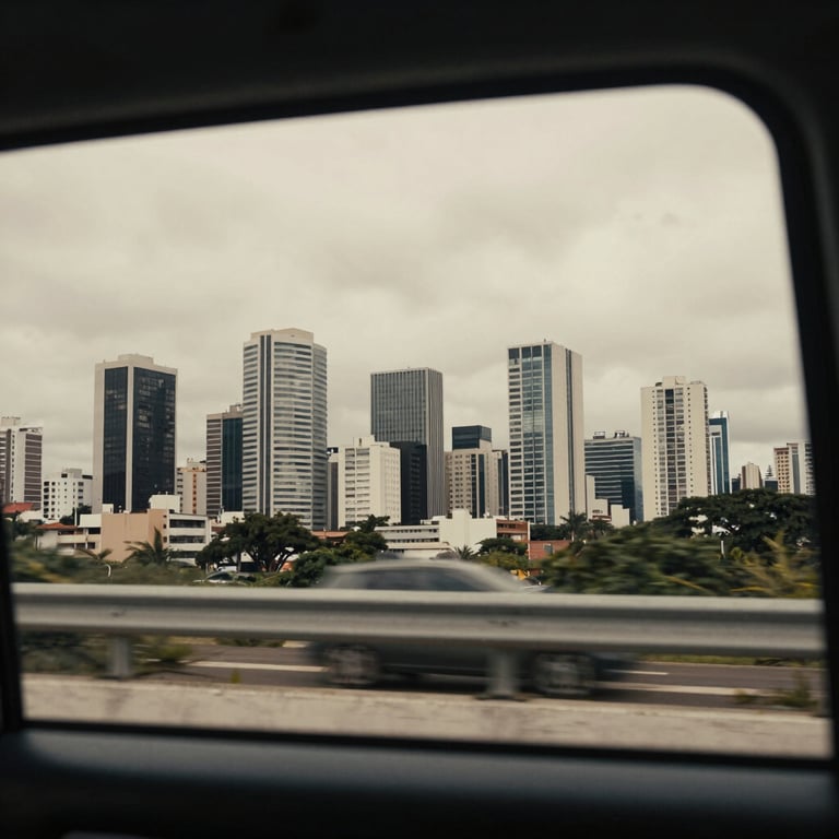A view of a modern South American / Brazilian skyline through the tinted window of a moving car, featuring soft off-white city lights.