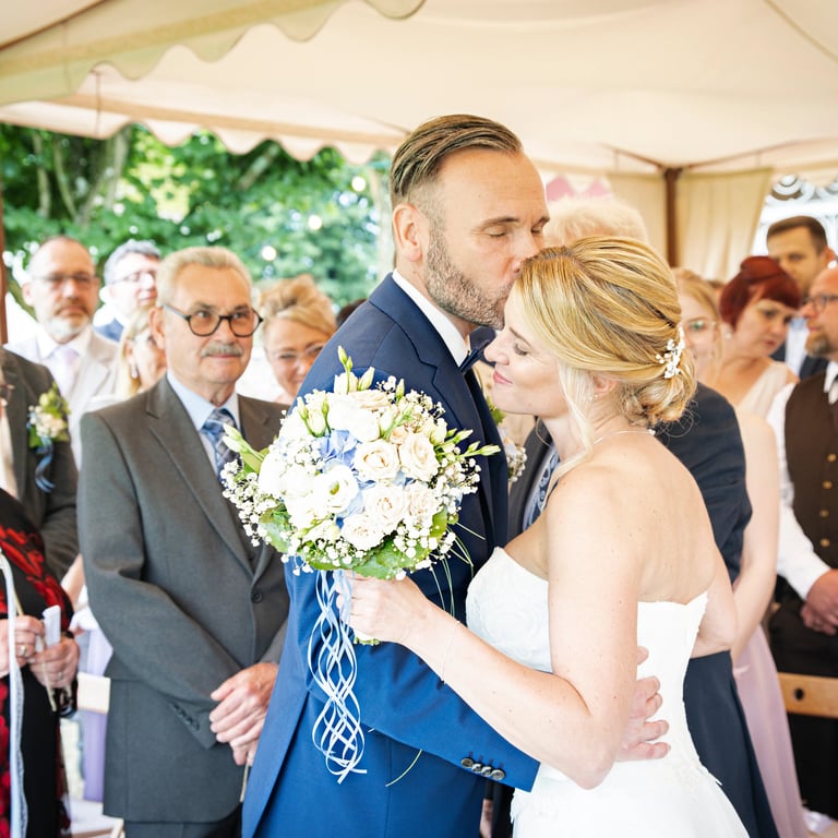 Brautpaar küsst sich während der Trauung am Möhnesee.