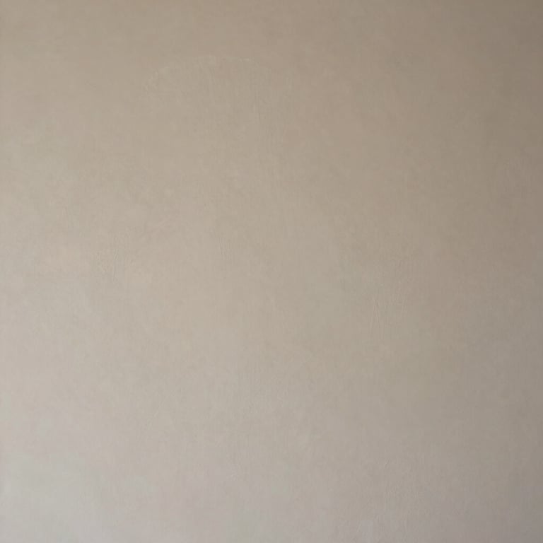 Detail of a smooth, repaired drywall section in a luxury home, perfectly textured and painted in a neutral beige.