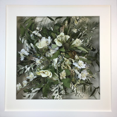 a photo of a Birdseye view preserved wedding bouquet in a frame