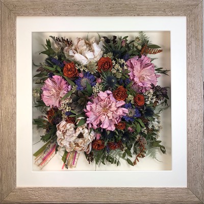 a photo of a Birdseye view preserved wedding bouquet in a frame