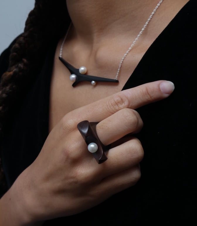 Handmade wooden jewelry set featuring a dark wood statement ring and necklace with white pearl accents.
