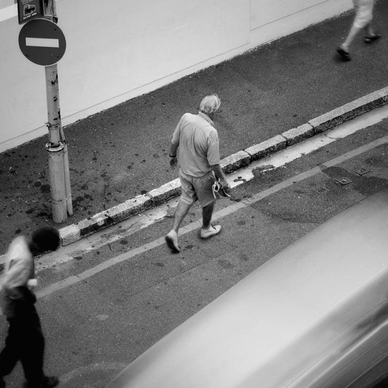 Elderly man walking past a no-enty sign on a quiet Cape Town street, captured in black-and-white fine art style.