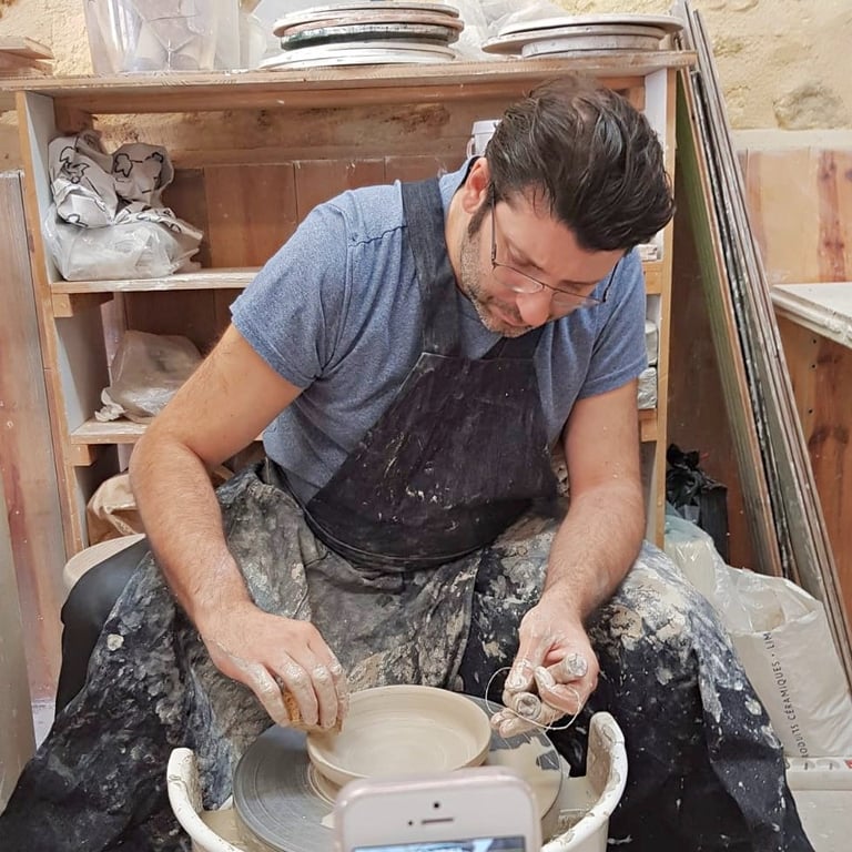 a man is throwing pottery plate on a wheel