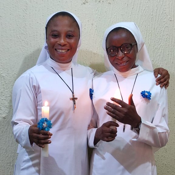 Catholic sisters holding candles in prayer and fellowship