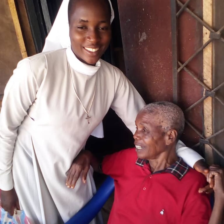 Missionary sister assisting an elderly woman with food and care