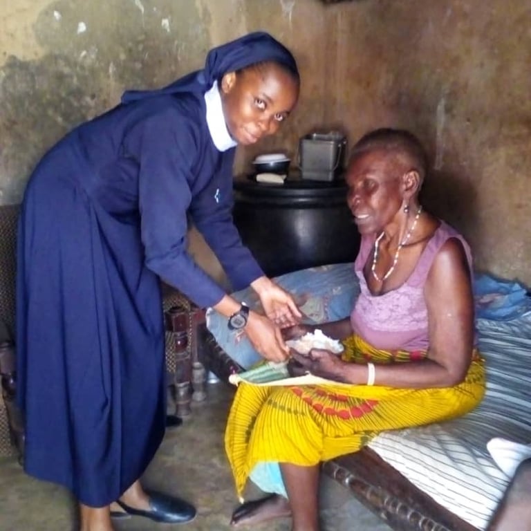 Catholic sister visiting and comforting an elderly woman