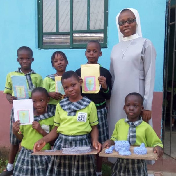 School children posing with books and educational supplies