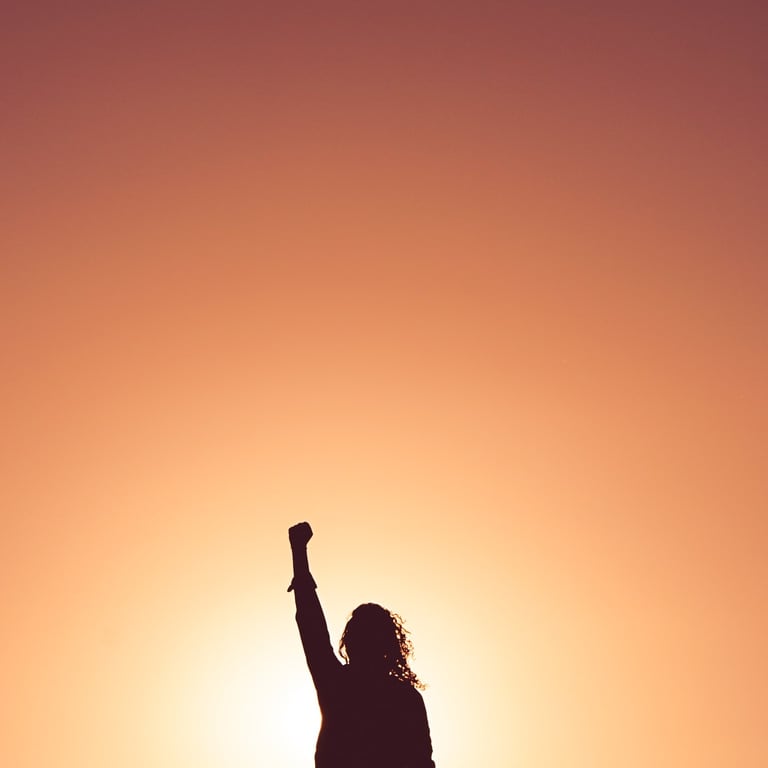 A confident woman with hand raised to sky
