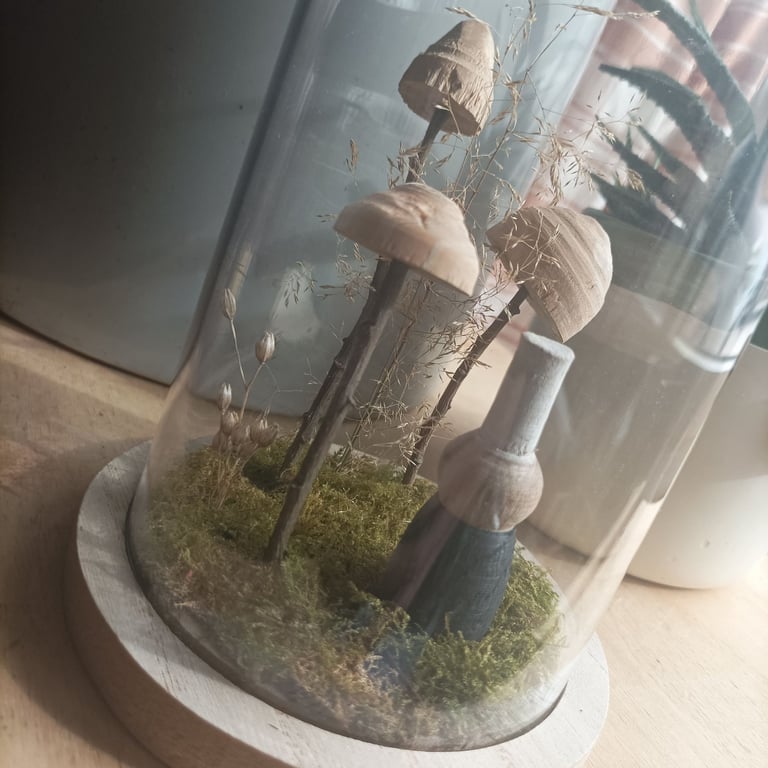 Bigoudène et champignons en bois sous cloche.