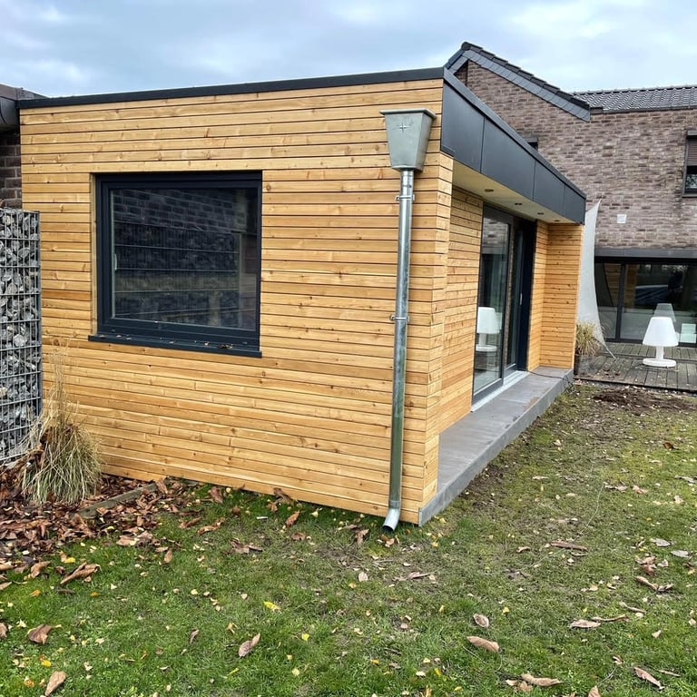 Budowa sauny ogrodowej z drewnianą elewacją, konstrukcja z desek poziomych, otwarta przestrzeń wejściowa, widoczne narzędzia