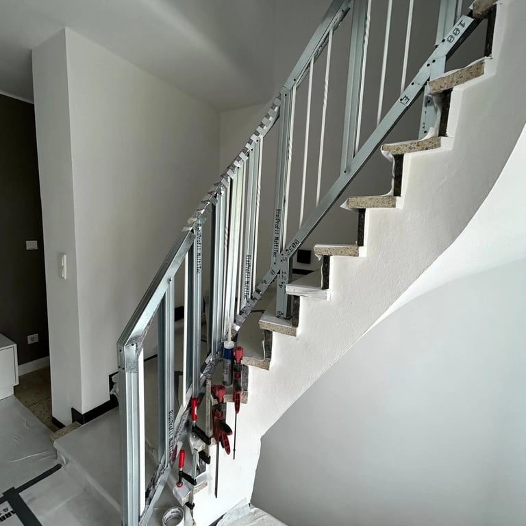 Metalowa konstrukcja zabudowy poręczy schodowej, profile stalowe zamocowane do stopni, przygotowanie pod montaż płyt gipsowyc