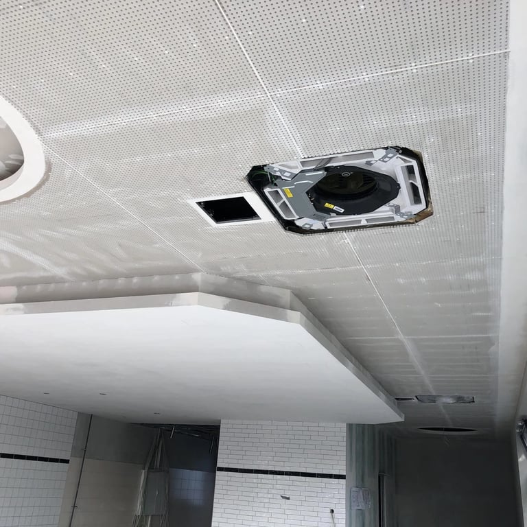 Sufit akustyczny z perforowanych płyt gipsowych, okrągły element dekoracyjny w centrum, przygotowanie pod oświetlenie.