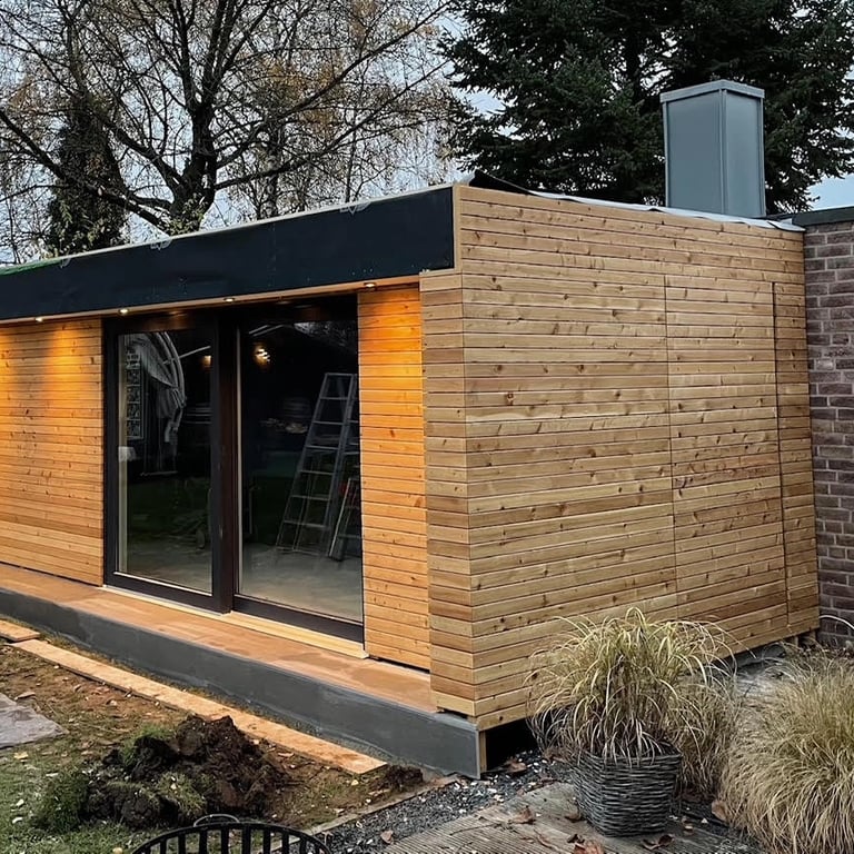 Wnętrze sauny z dużym oknem, drewniane ściany i sufit, podłoga z szarych płytek ceramicznych.