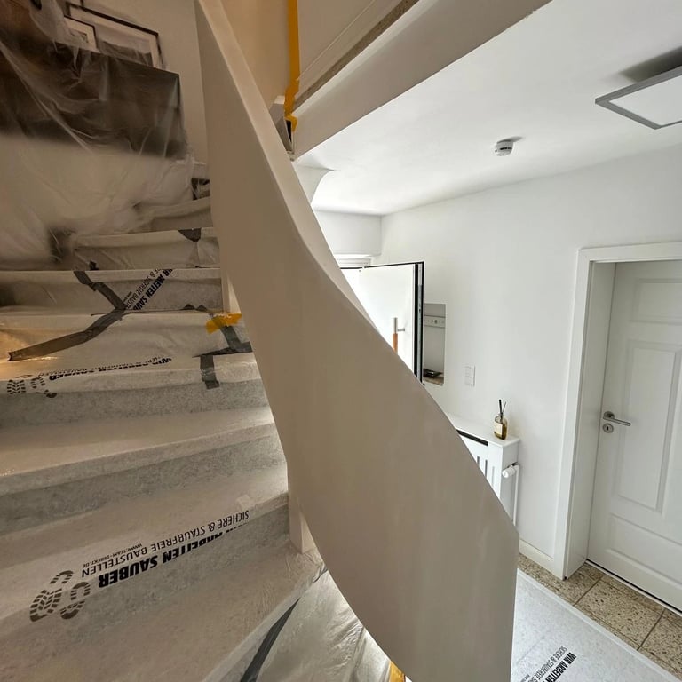 Zabudowa poręczy schodowej w domu jednorodzinnym, płyta gipsowa zamontowana na konstrukcji, widoczne zabezpieczenia schodów.