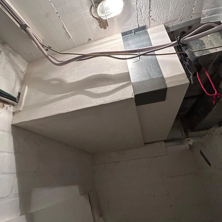 Zabudowa przeciwogniowa w piwnicy, płyty ognioodporne wokół kanałów wentylacyjnych i przewodów elektrycznych.