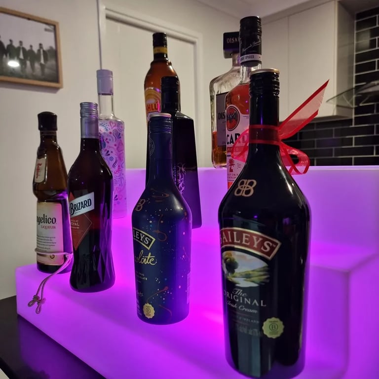 Glow Stand with bottles behind the bar at a New Years party in Redlandbay, Redlands - party hire by SweetAz Co.