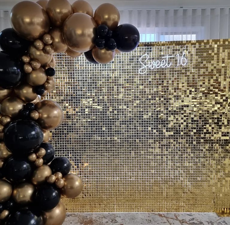 Gold shimmer wall with matching gold and black garland for sweet 16 in Brisbane.