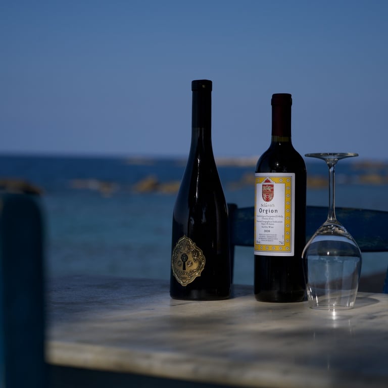 2 bouteilles de vin daskalaki et sclavos posées sur une table en bord de mer