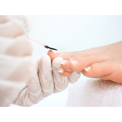 Nagellak wordt zorgvuldig aangebracht op de teennagels door een pedicure specialist.