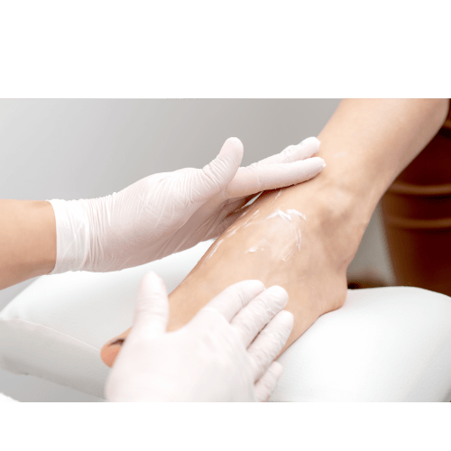 Voetverzorging met hydraterende crème aangebracht door een pedicure.