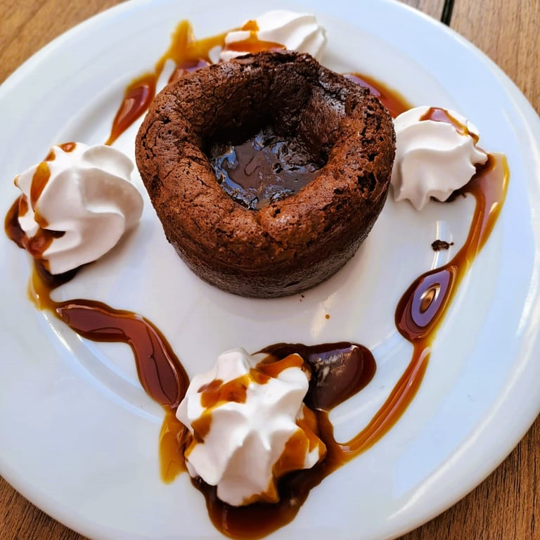 Coulant de chocolate que refleja la historia del Bar Las Tinajas Huelva, con presentación cuidada y sabor tradicional.