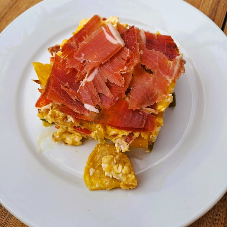 Revuelto de huevo con jamón presentado en la galería del Bar Las Tinajas Huelva, con aroma y sabor casero.