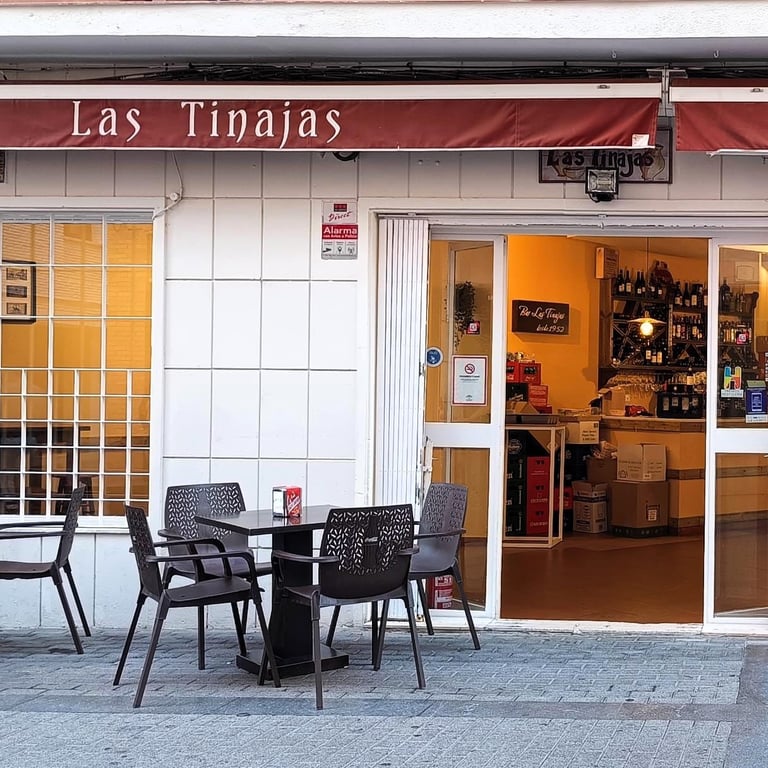 Vista exterior del Bar Las Tinajas Huelva, con mesas al aire libre, invitando a disfrutar de la comida.