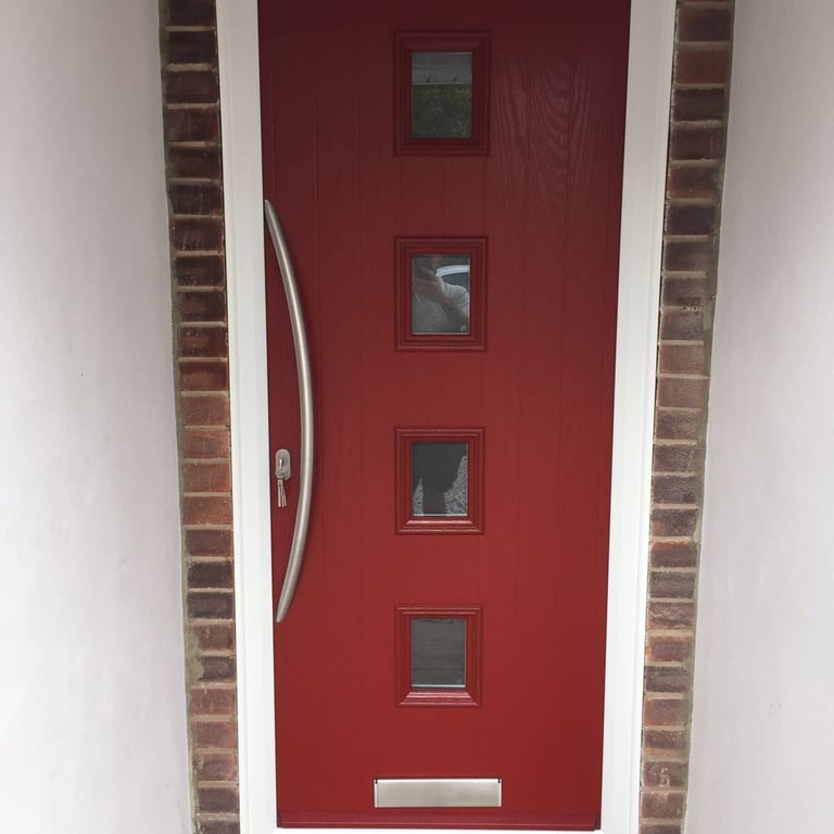 a new red composite front door with 4 squares of glass and curved long handle