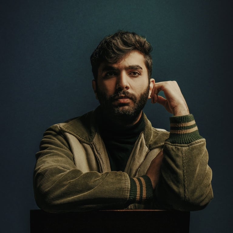 a man sitting in a chair with his hand on his chin