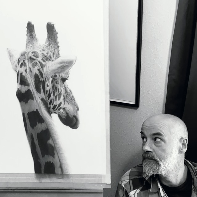 A photo of Will Arden with a drawing of a giraffe