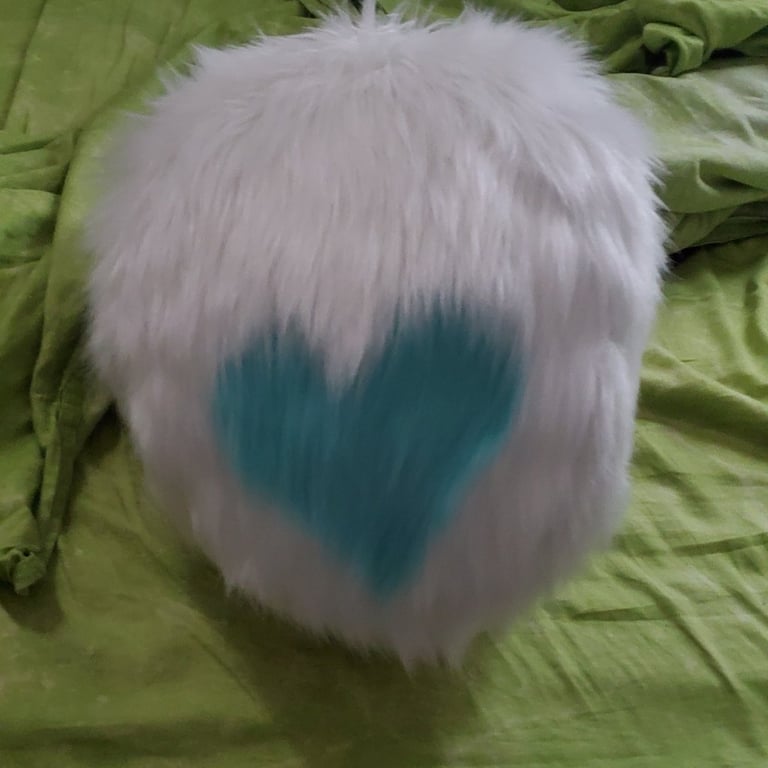 A puffball tail with a blue heart made by Teto Creations