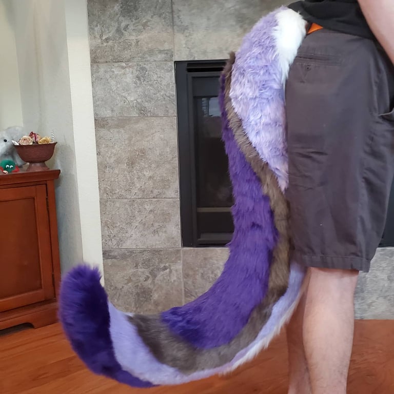 A wolf tail with many colors including purple and grey made by Teto Creations