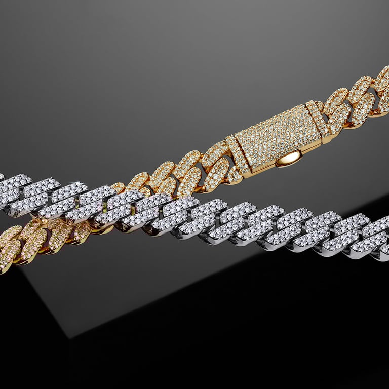 Two pave-diamond Cuban chains, one gold and one silver, with a gold diamond-encrusted clasp photography studio LA