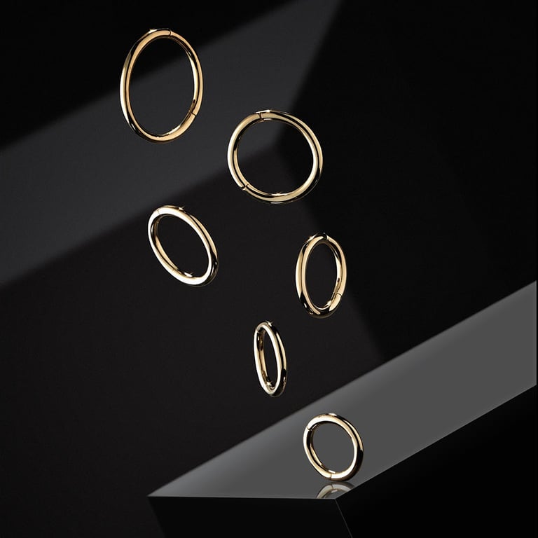 Abstract professional jewelry photo: six gold hoop "clicker" earrings floating above a reflective black surface with dramatic
