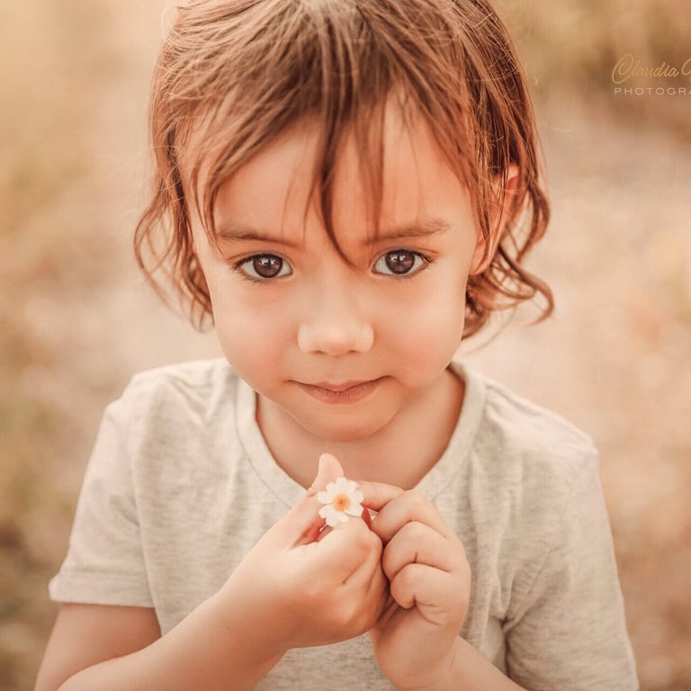 niño con una margarita en sus manos