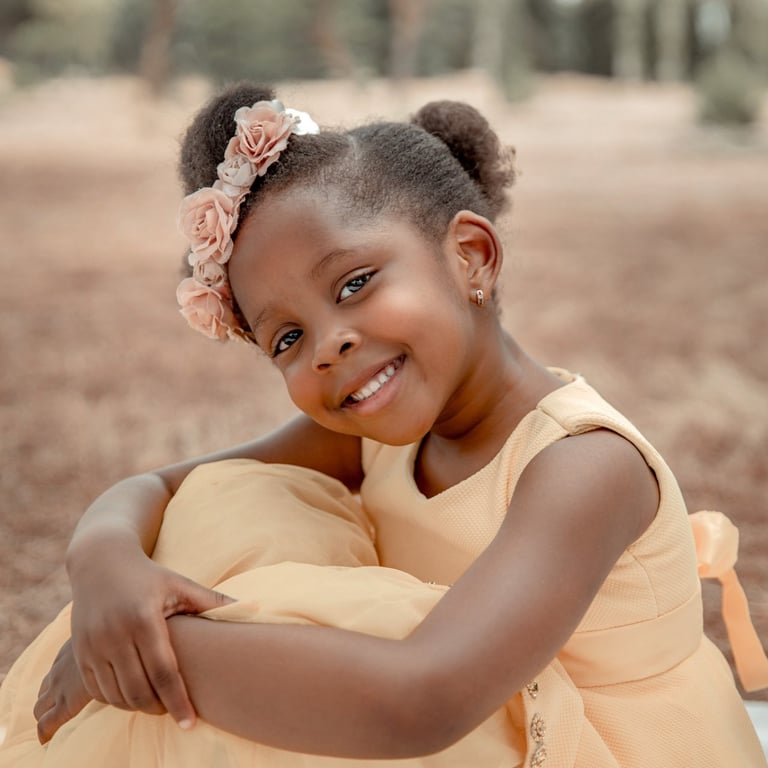 niña sentada sonriendo en el campo con todos amarillos