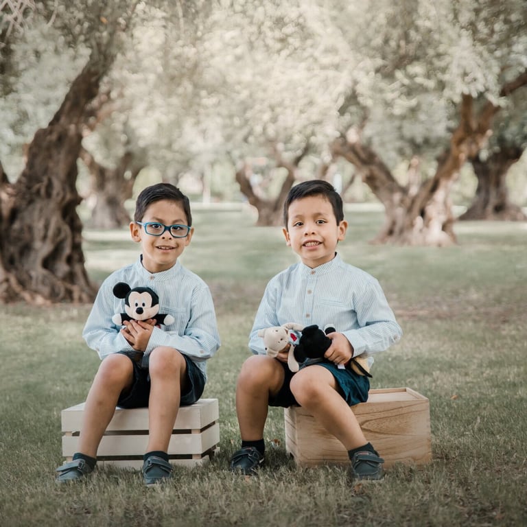 dos niños sentados sobre cajones en tre olivos