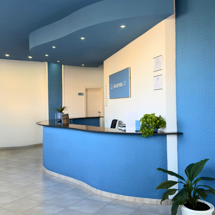 Recepción de la Clínica Bocarriba en El Médano, Tenerife sur, con un mostrador curvo azul