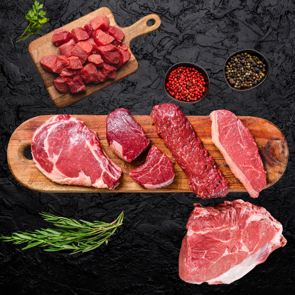 Sélection de morceaux de bœuf cru frais sur une planche en bois.