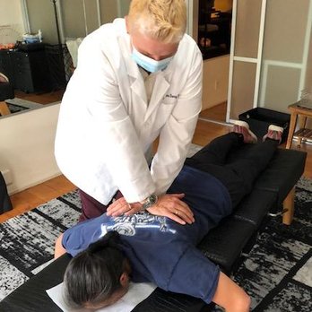 Dr. Lonna Denny performing a traditional spinal adjustment to a patient.