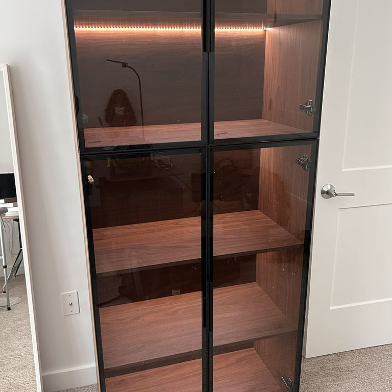 A brown 5-tier display cabinet with 4 glass doors and lighted shelves, assembled for a client in Woburn, MA..