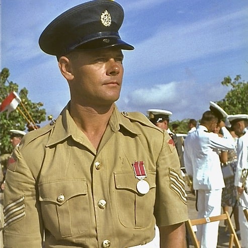 Sgt Roland Pickering B.E.M. in uniform standing in front of a group of people