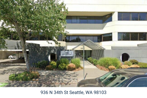 A white commercial office building with covered parking.