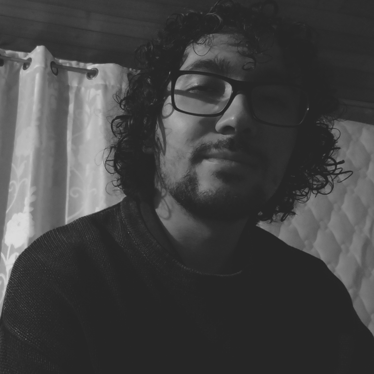 Autorretrato en blanco y negro de hombre con gafas y barba.