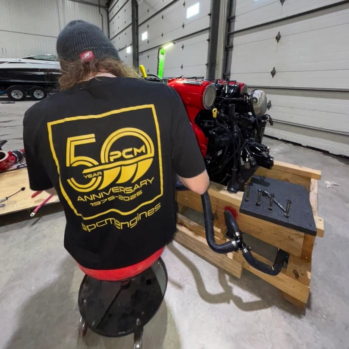 STO Boats technician assembling PCM ZZ6 inboard engine for wake and surf boat in Ontario