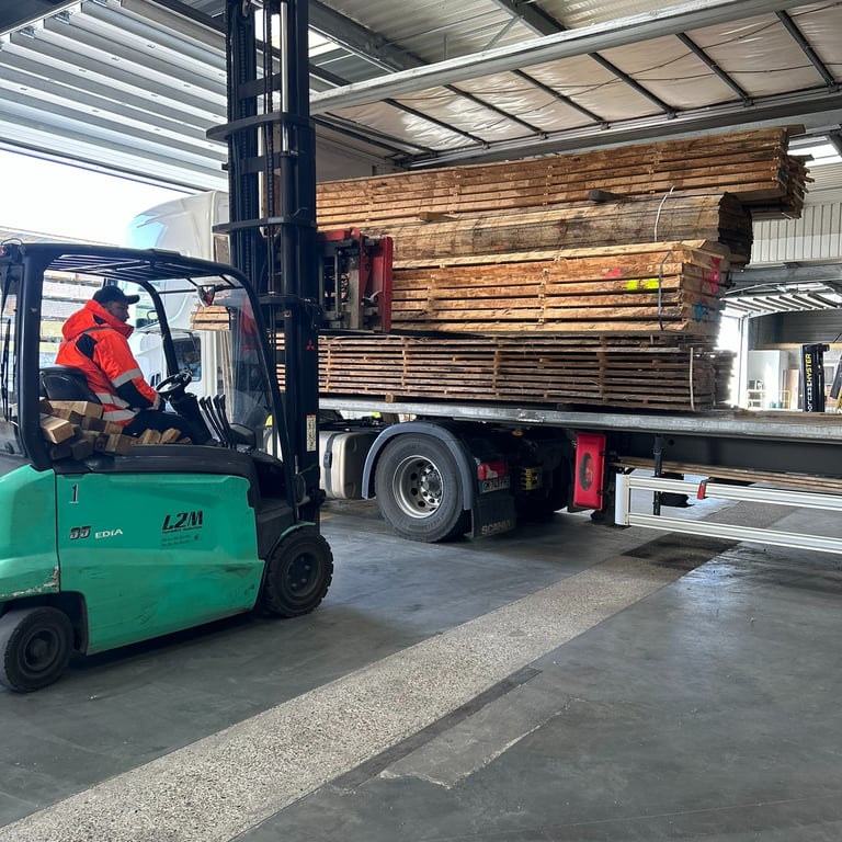 déchargement de bois dans le dépôt ouvert de la coopérative a l'aide d'un transpalette